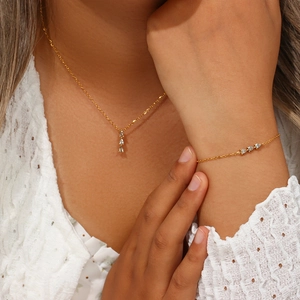 Detail of 18K gold plated necklace and bracelet set with three sparkling zircon stones