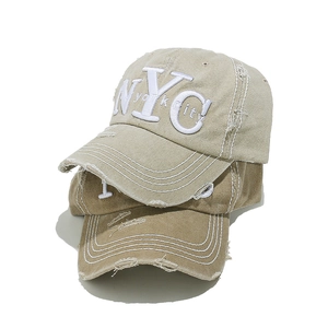 Close-up of distressed cotton baseball caps with NYC embroidery and vintage ripped details