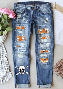 Détail du jean bleu déchiré avec écusson tête de mort et imprimé sur le bas de jambe