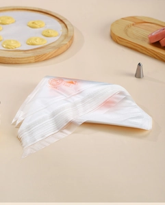 Close-up of disposable piping bags with orange birthday prints and metal nozzles