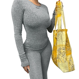 Detail of the grey knit texture and ribbed fabric on a slim fit long sleeve top for women