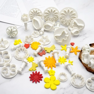 33-piece white plastic fondant and cookie cutter set with various floral and star shapes