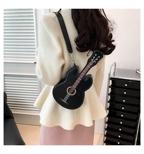 Detail of guitar-shaped black crossbody bag with adjustable strap and silver hardware accents
