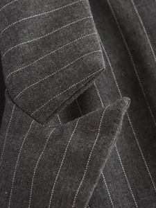Gros plan détaillé sur la texture du tissu gris foncé à rayures et les coutures
