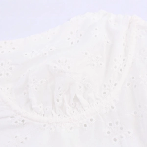 White eyelet embroidery midi dress with intricate floral cutouts and lace detailing