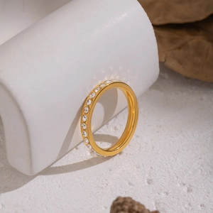 Detail of gold-plated stainless steel eternity ring with inset white zircon stones