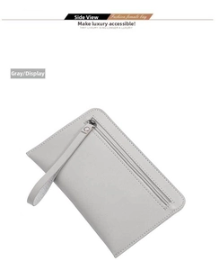 Detail view of the gray clutch bag with textured finish, wrist strap, and silver zipper