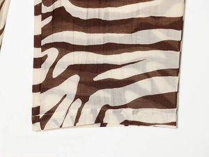 Détail du tissu à imprimé zèbre transparent avec rayures marron et beige et couture