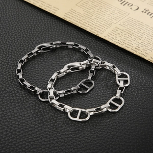 Close-up of vintage anchor chain bracelets in silver and matte tones on black leather