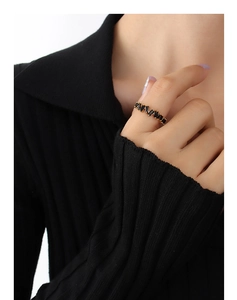 Detail of 18K gold-plated ring with baguette-cut black zircon stones in a zigzag pattern