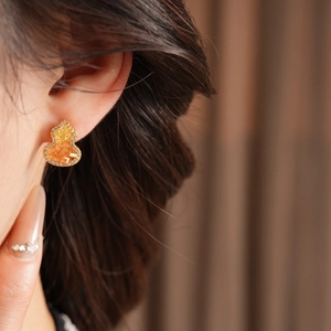 Gros plan détaillé des boucles d'oreilles gourde plaquées or 18K avec zircon et perle