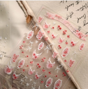 Macro detail of floral nail stickers with pink roses, bows and Rose Magic text