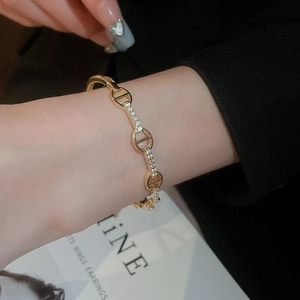Close-up of gold-plated oval bracelet with pavé-set cubic zirconia on female wrist