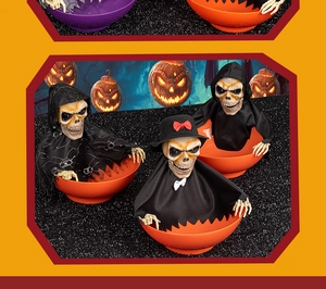 Close-up of three Halloween candy bowls with animated skeletons and LED lights decor