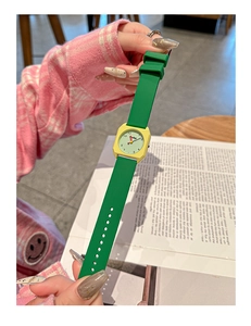 Close-up of square yellow dial and green silicone strap of a stylish student watch