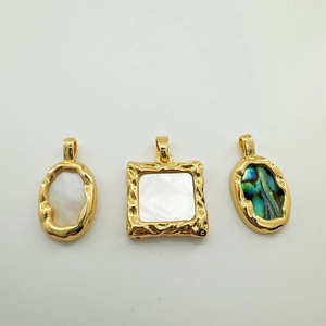 Macro view of 18K gold plated pendants with inlaid natural white and abalone shell