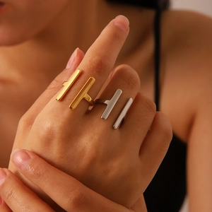 Close-up of minimalist double-bar open rings in gold and silver on a model's hand