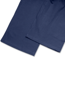 Détail du pantalon large bleu marine montrant le tissu en coton lin et l'ourlet de qualité
