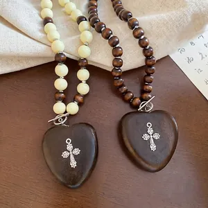 Collier ethnique en perles avec cœur en bois et pendentif croix argentée à fermoir OT