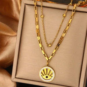 Double-layered gold necklace with beaded chain and sparkling diamond eye pendant