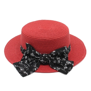 Red straw boater hat with a floral print ribbon and large bow for summer beach sun protection