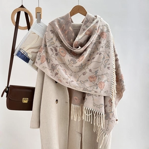 Close-up of beige pashmina shawl with pink floral jacquard and soft tassel details
