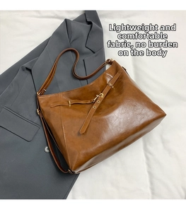 Detail of vintage brown Hobo bag texture with gold hardware on gray blazer