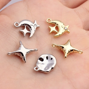 Mini metal star and moon charms for DIY jewelry making shown in hand for size