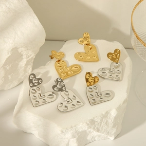 Hammered 18K gold and silver heart earrings with layered textured metal drop design
