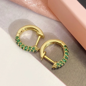 Classic gold hoop earrings with green micro-pave cubic zirconia on silk background