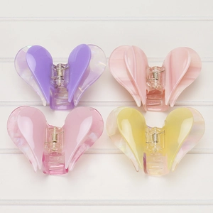 Close-up of heart-shaped acetate hair claws in pastel purple, pink, and yellow colors