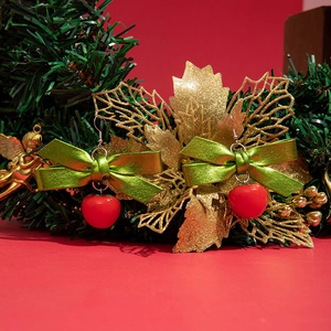 Détail de boucles d'oreilles de Noël avec pommes rouges et nœuds verts sur décor festif