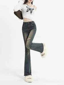 Détail du jean évasé gris à taille haute avec genou déchiré et délavage vintage chic