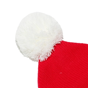 Détail macro d'un pompon blanc moelleux sur un bonnet de Noël rouge tricoté festif