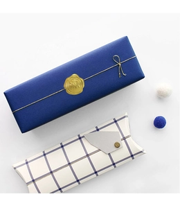 Detail of gold wax seal stickers on elegant blue gift boxes and white pillow packaging