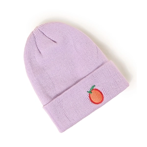 Détail du tissu en maille violette épaisse et broderie de fruits sur le revers du bonnet