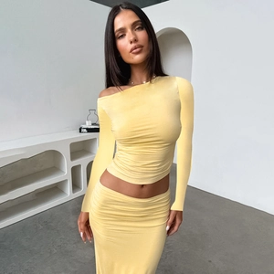 Detailed view of the light yellow pleated fabric and textured ribbed knit of the set