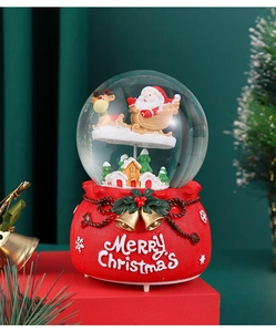 Macro detail of Christmas snow globe with Santa sleigh and red lucky bag base