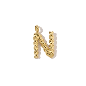 Macro detail of a 18k gold-plated stainless steel letter N pendant with twist texture