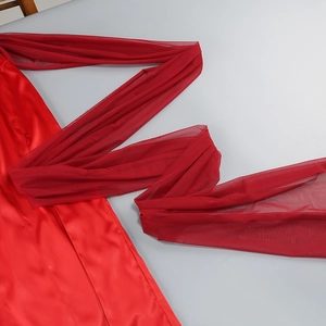 Detail of red satin evening dress featuring glossy fabric and matching mesh ribbon accent