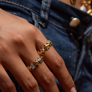 Close-up of dual-tone 18K gold and silver star rings worn for a stylish look