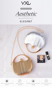 Detail of round metallic evening clutch with pleated texture and stylish metal handle