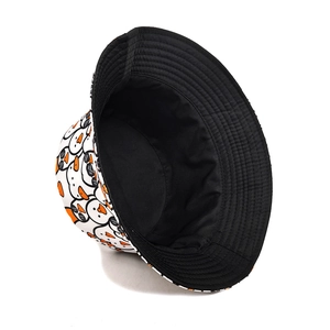 Detail of white bucket hat featuring cute cartoon duck print and black inner lining