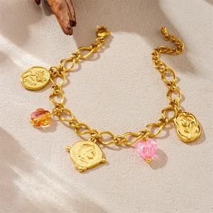Detailed close-up of vintage gold charm bracelet with rose tag and 1973 coin charms