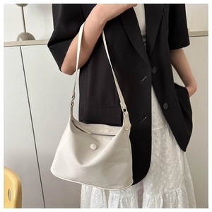 Detail of minimalist beige oxford shoulder bag with smooth leather texture and zip closure
