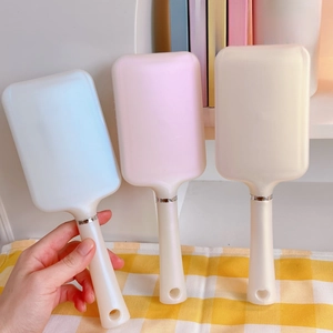Drei elegante quadratische Haarbürsten in Blau, Rosa und Beige mit weißen Griffen für den Alltag