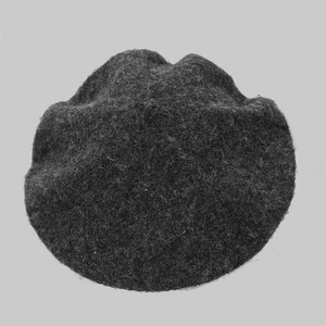 Detailed macro view of dark grey wool felt beret showing warm fiber texture