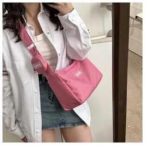 Détail du sac bandoulière rose en nylon avec son petit porte-monnaie rond assorti