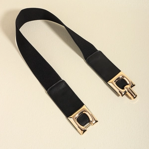Close-up of black elastic waist belt featuring golden interlocking buckles and textured leather