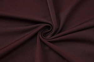 Gros plan sur un tissu en maille marron foncé avec des plis élégants et une texture fine